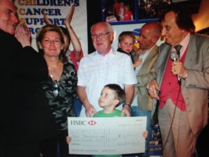 Ken Dodd presented four-year-old Tom Culley with the cheque. Pic © JMU Journalism 