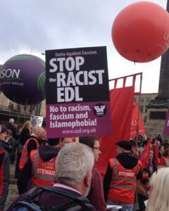 One of many protesters holding anti-fascism placards.