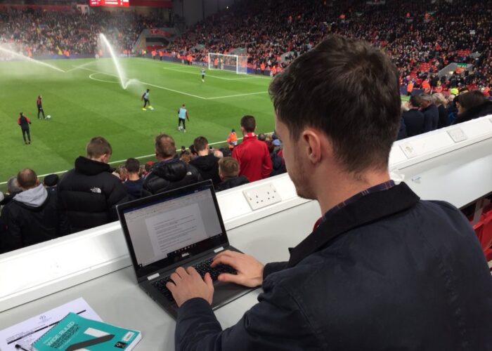 Joe Maude working in the Anfield press box on a Champions League night - JMU Journalism